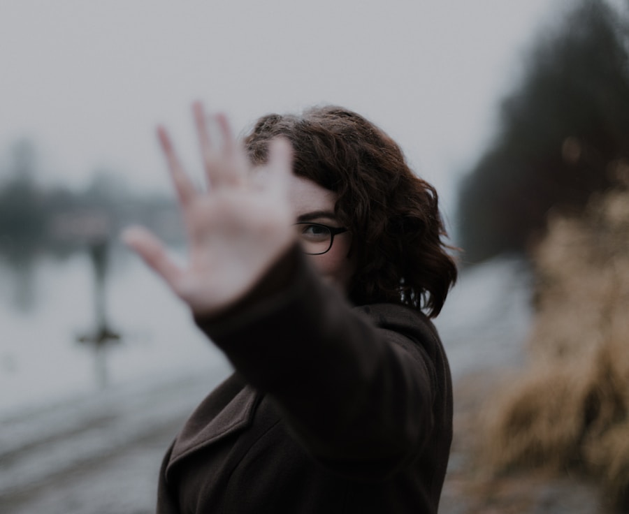 woman in black coat standing near body of water during daytime